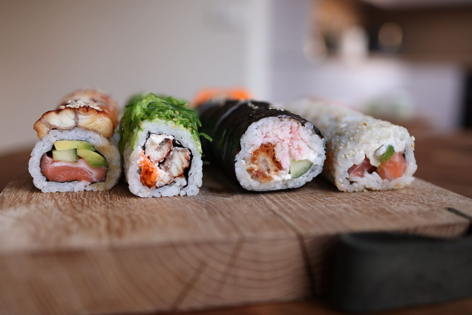 Close-up of assorted sushi rolls on a wooden board showcasing fresh ingredients.