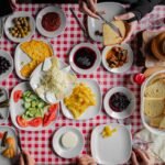 Colorful assortment of traditional Turkish breakfast dishes on a red checkered tablecloth.
